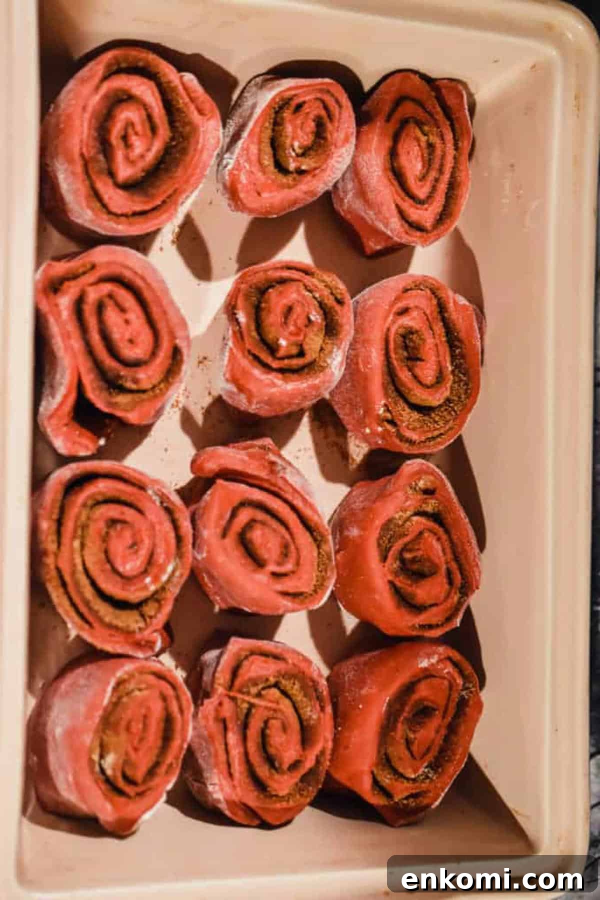 Homemade Red Velvet Cinnamon Rolls with Cream Cheese Glaze 6 The cut rolls are placed in the baking dish.