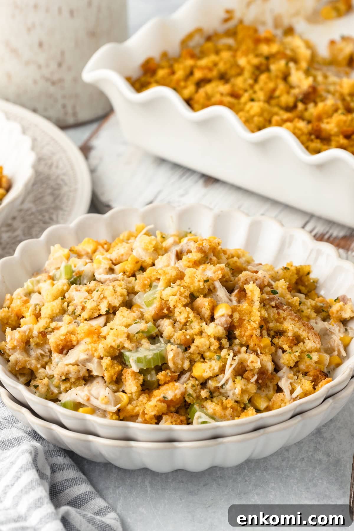 Creamy Chicken and Savory Stuffing Casserole Recipe 2 A white scalloped bowl filled with chicken and cornbread stuffing.