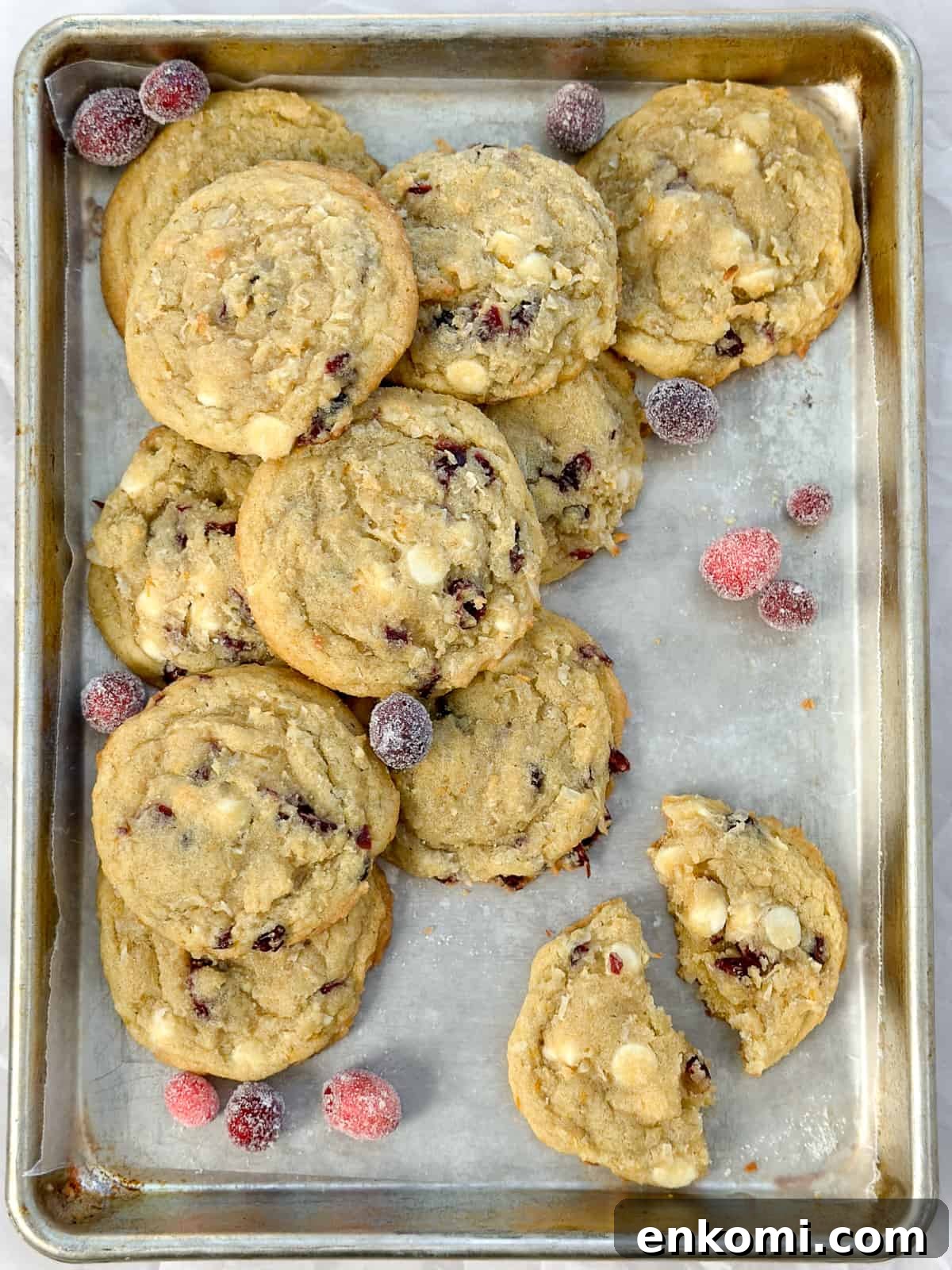 White Chocolate, Cranberry & Orange Cookies — Holiday Citrus Treats 2 a bunch of white chocolate orange cranberry cookies on a cookie sheet with some candied cranberries.