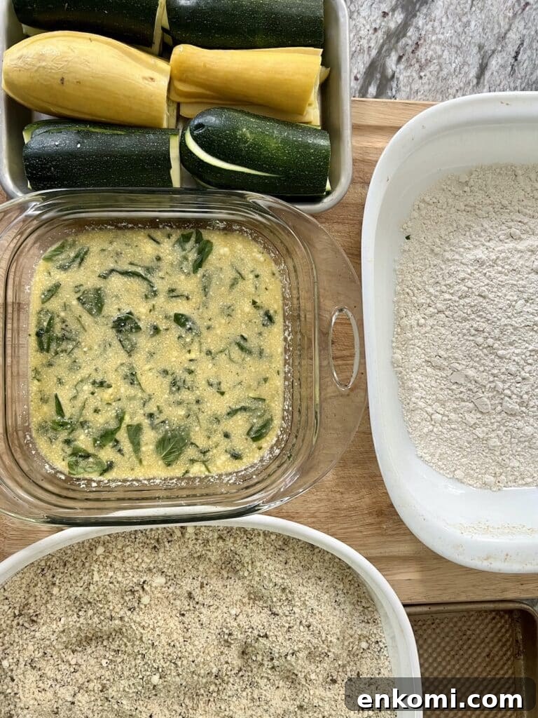 Sliced vegetables, egg mixture, seasoned breadcrumbs and flour breading set up.