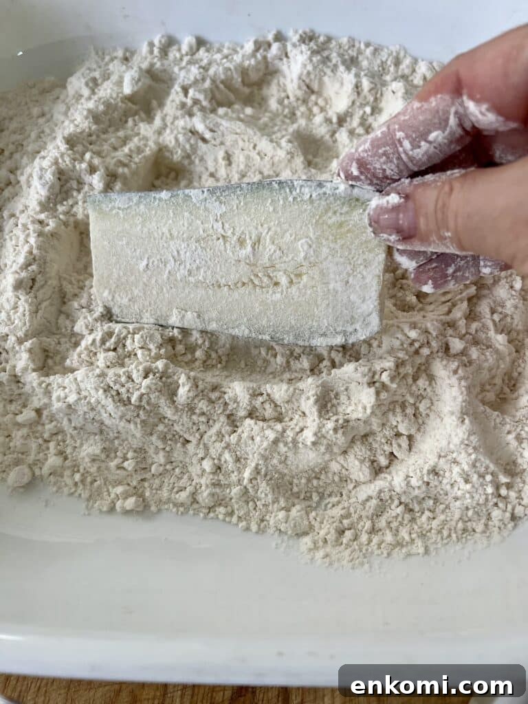 Piece of zucchini coated in flour.