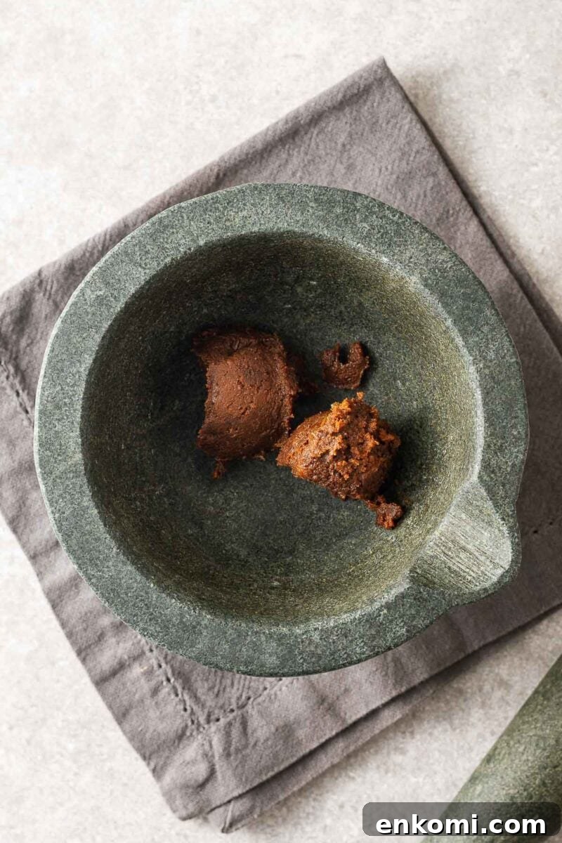 Miso Substitutes and Alternatives: What to Use — and What to Avoid 4 Two tablespoons of doenjang paste in a mortar bowl viewed from above.