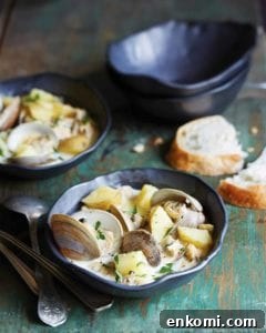 North Carolina-Style Clam Chowder Recipe: Creamy Coastal Flavor 3 Two bowls of North Carolina clam chowder with a torn slice of bread, two empty bowls, and several spoons beside them.