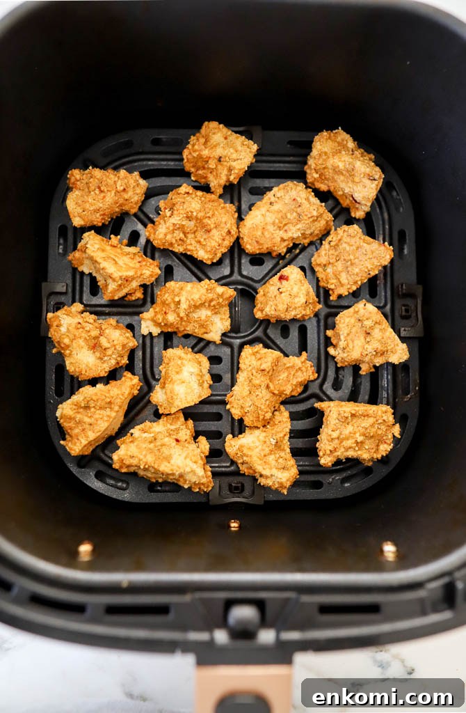 tofu cubes in air fryer basket in a single layer