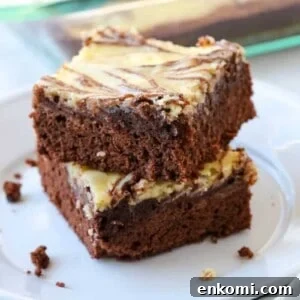 Two marble brownies stacked on a plate.