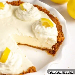 lemon cream pie with graham cracker crust served in a pie dish.