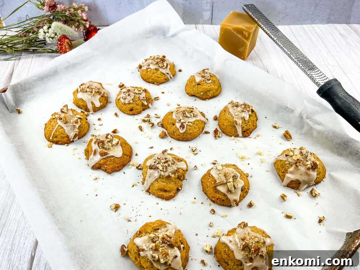29 Fall Desserts That Bring Generations of Flavor Together 16 Sweet Potato Cookies on a baking sheet with icing and nuts.