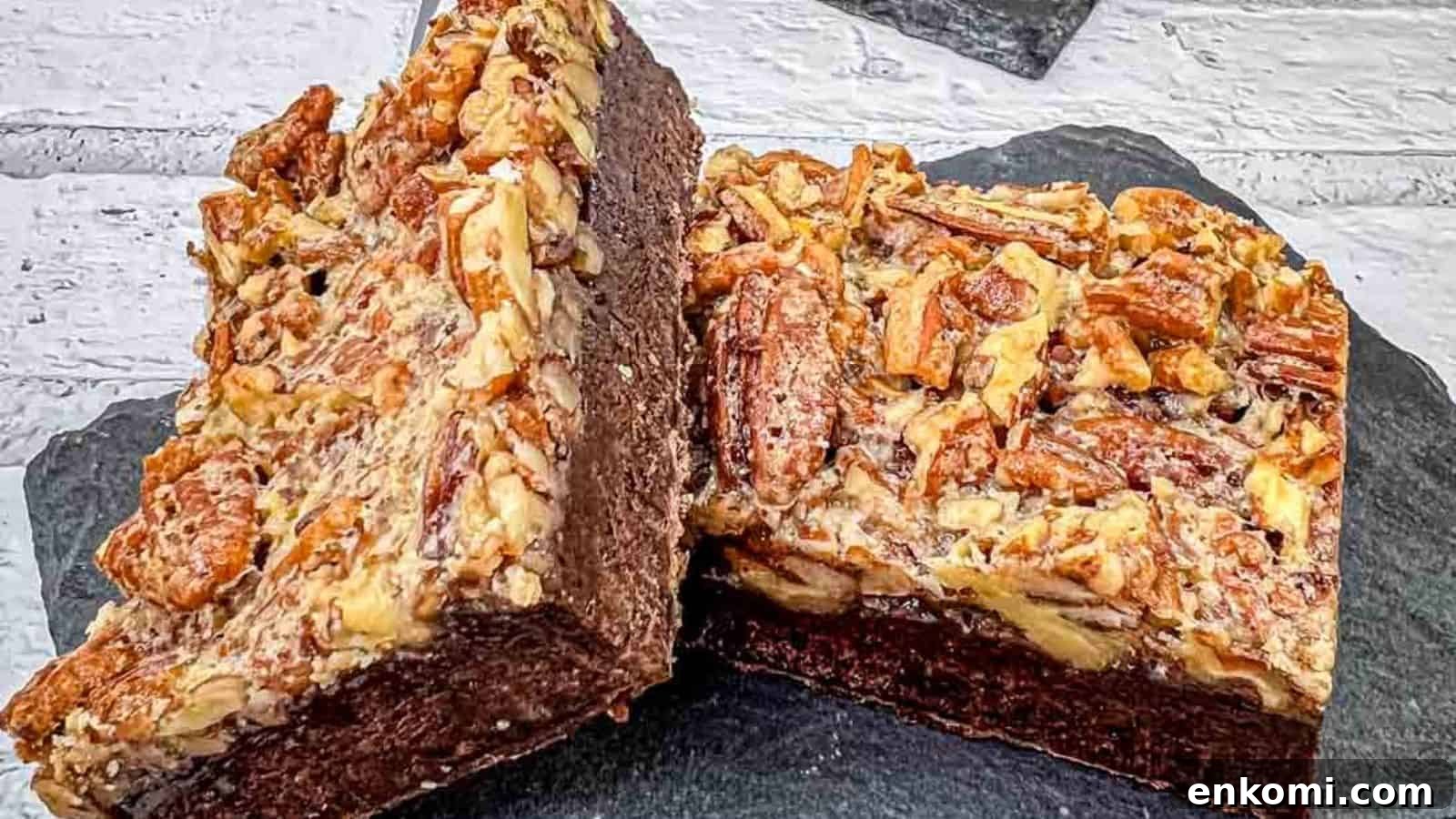 29 Fall Desserts That Bring Generations of Flavor Together 20 A close-up of two pecan brownies on a slate surface, showing the rich, chocolatey interior and a topping of chopped pecans.