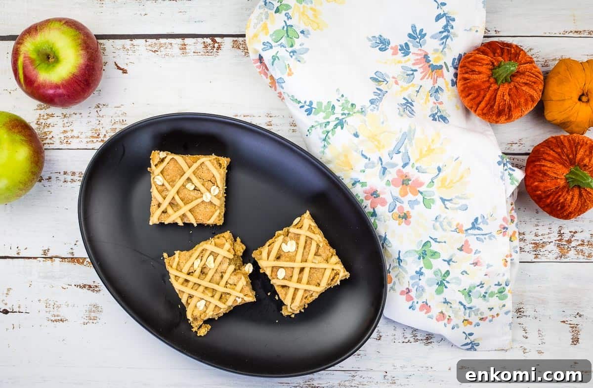 29 Fall Desserts That Bring Generations of Flavor Together 23 Two brown butter apple blondies placed on a white surface.
