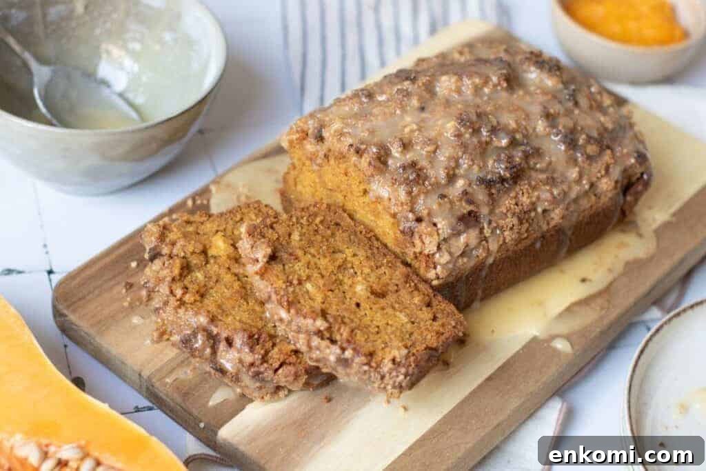 29 Fall Desserts That Bring Generations of Flavor Together 31 A loaf of glazed pumpkin bread with two slices cut sits on a wooden cutting board.