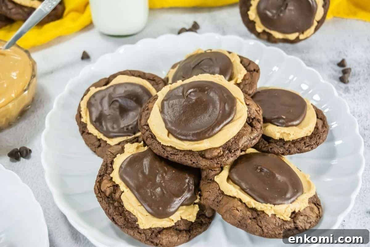 29 Fall Desserts That Bring Generations of Flavor Together 5 A plate with several Crumbl Copycat Buckeye brownie cookies topped with a layer of peanut butter and a swirl of chocolate frosting.