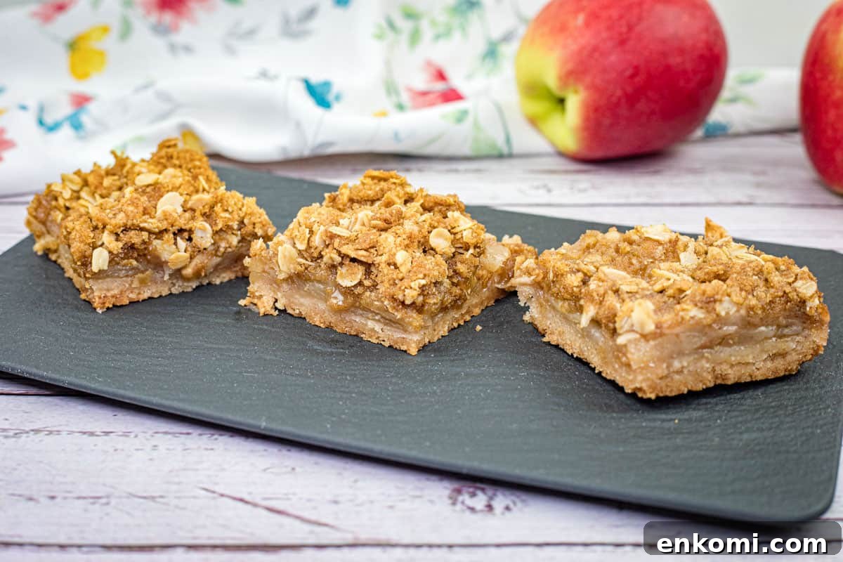 29 Fall Desserts That Bring Generations of Flavor Together 7 Three pieces of Dutch Apple Pie Squares on a black slate plate.