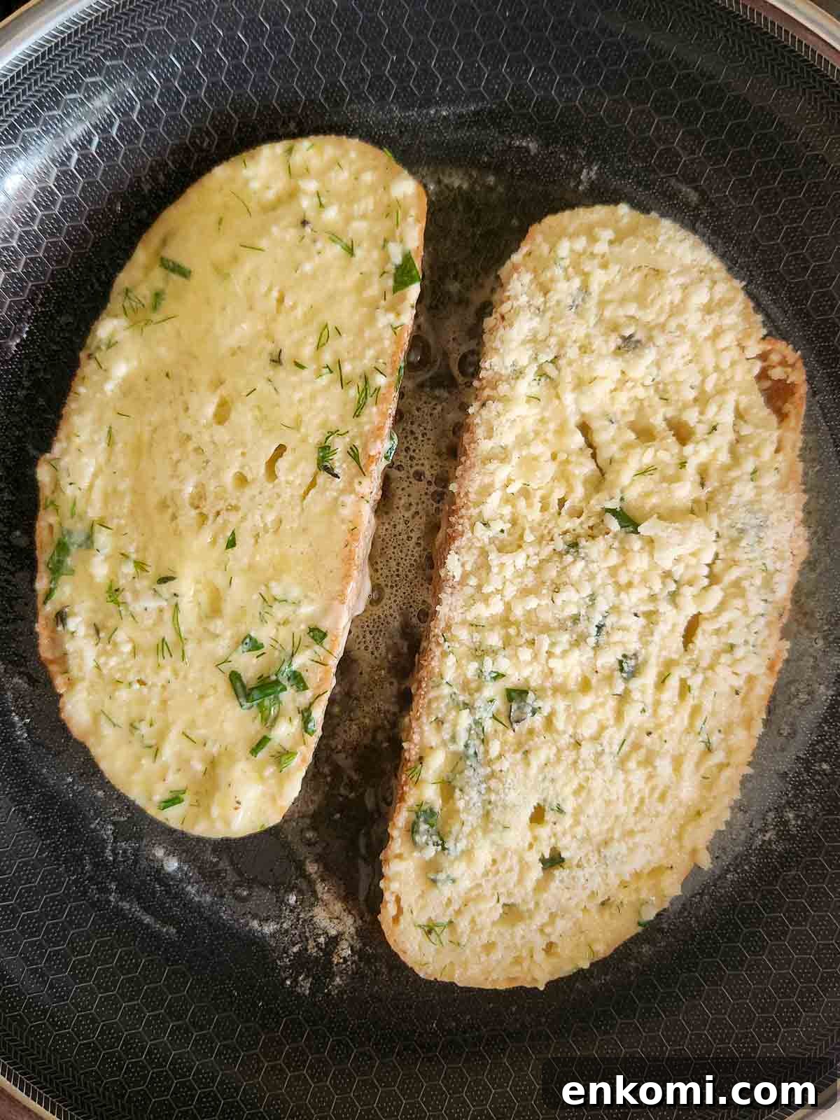 Parmesan, Lemon & Herb Savory French Toast Recipe 8 Two slices of French toast in a pan being sauteed.