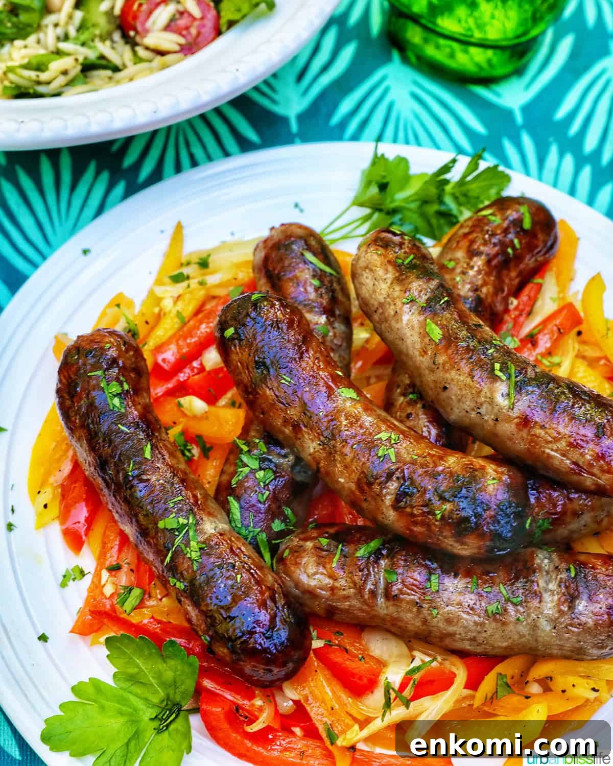 plate of grilled bratwurst over sauteed peppers.