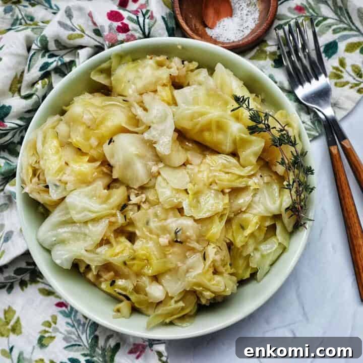 bowl of cooked instant pot cabbage with thyme sprigs and forks.