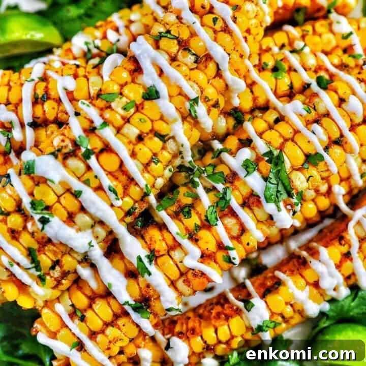 closeup photo of air fryer corn ribs stacked on top of one another with drizzled mayo and chopped cilantro.