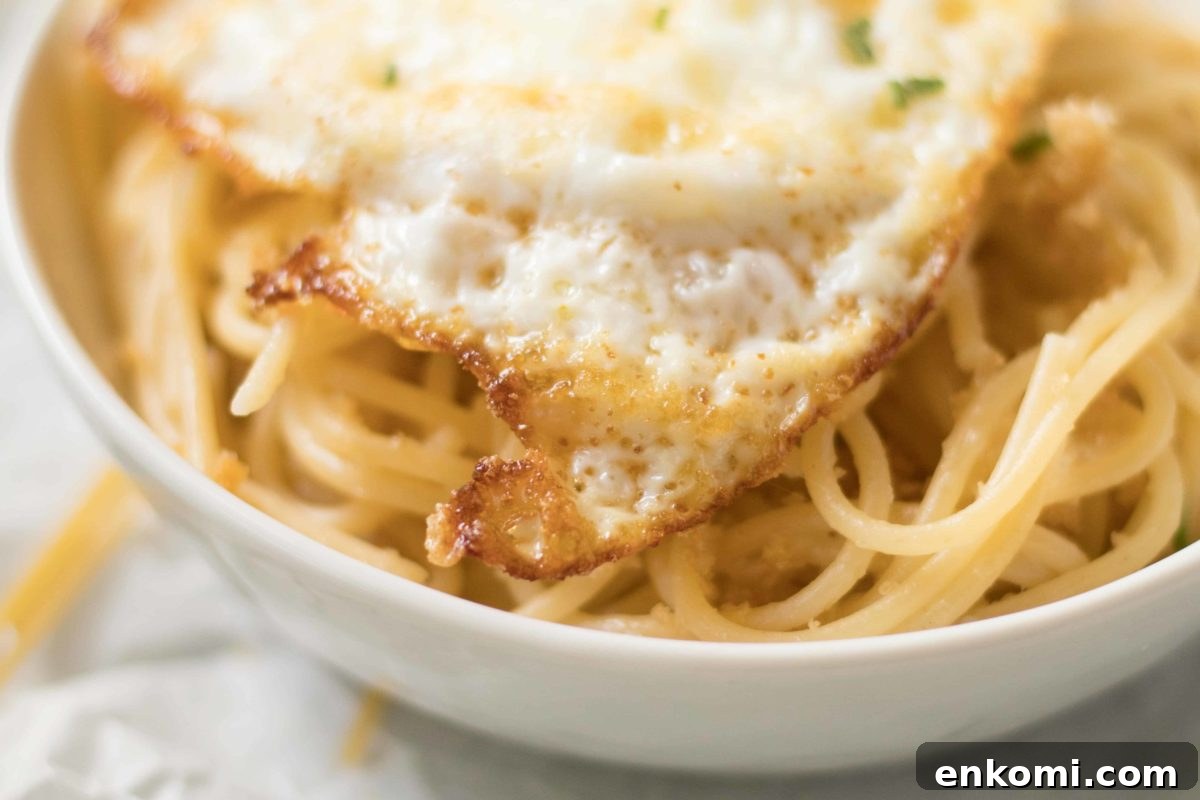 up close crispy edge of a fried egg over pasta pangrattato