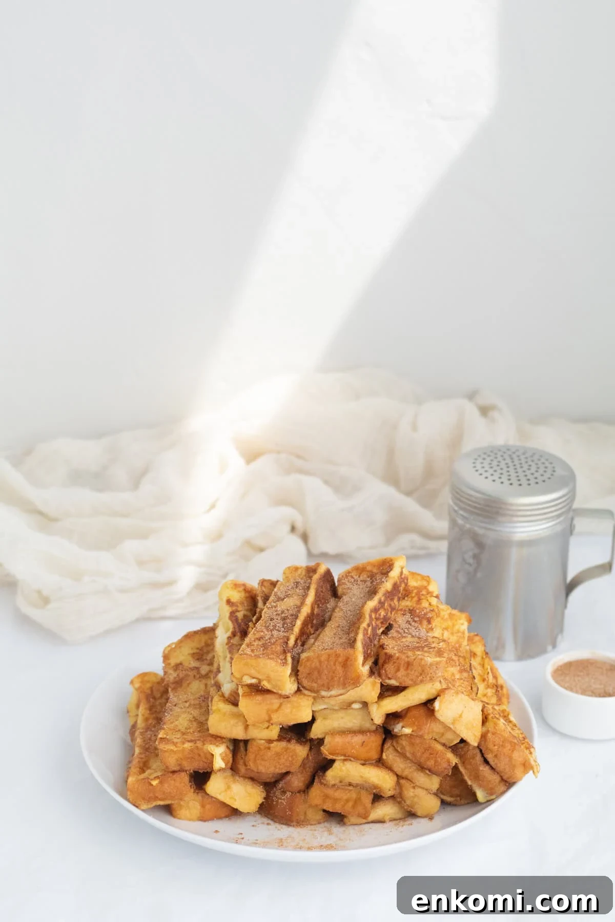 a pile of french toast sticks on a white plate