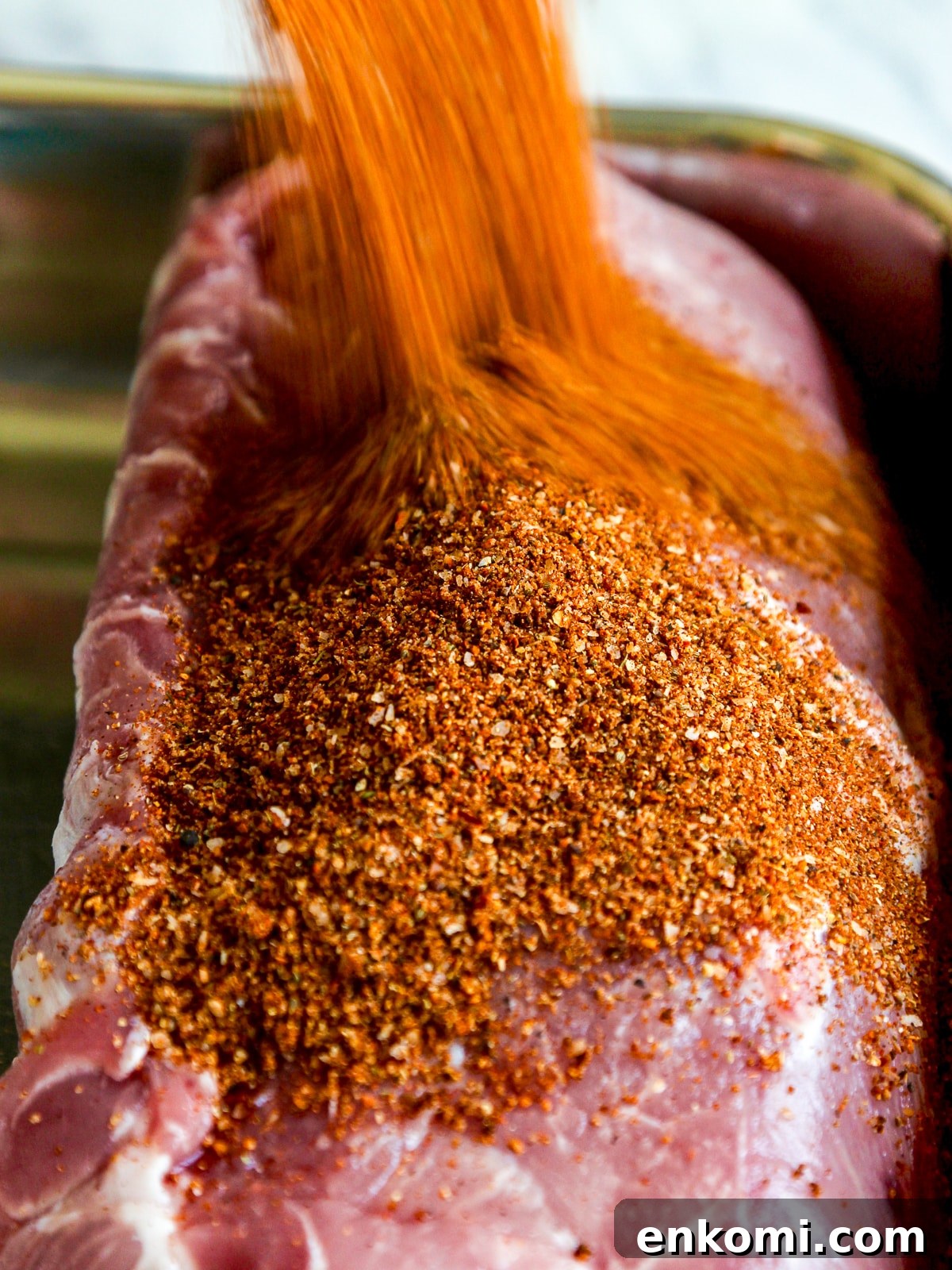 Juicy Oven-Roasted Pulled Pork 6 Pork loin with dry rub being poured on