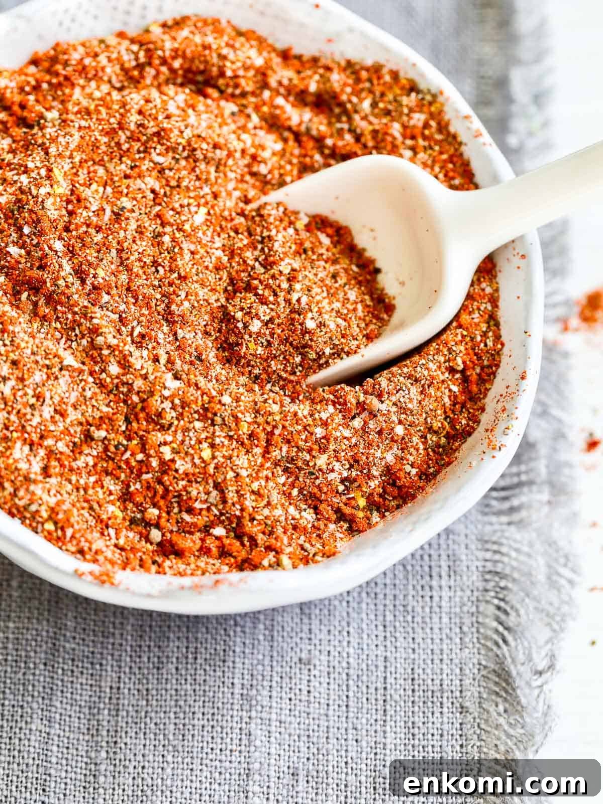 Juicy Oven-Roasted Pulled Pork 5 Dry rub in a small white bowl with scoop