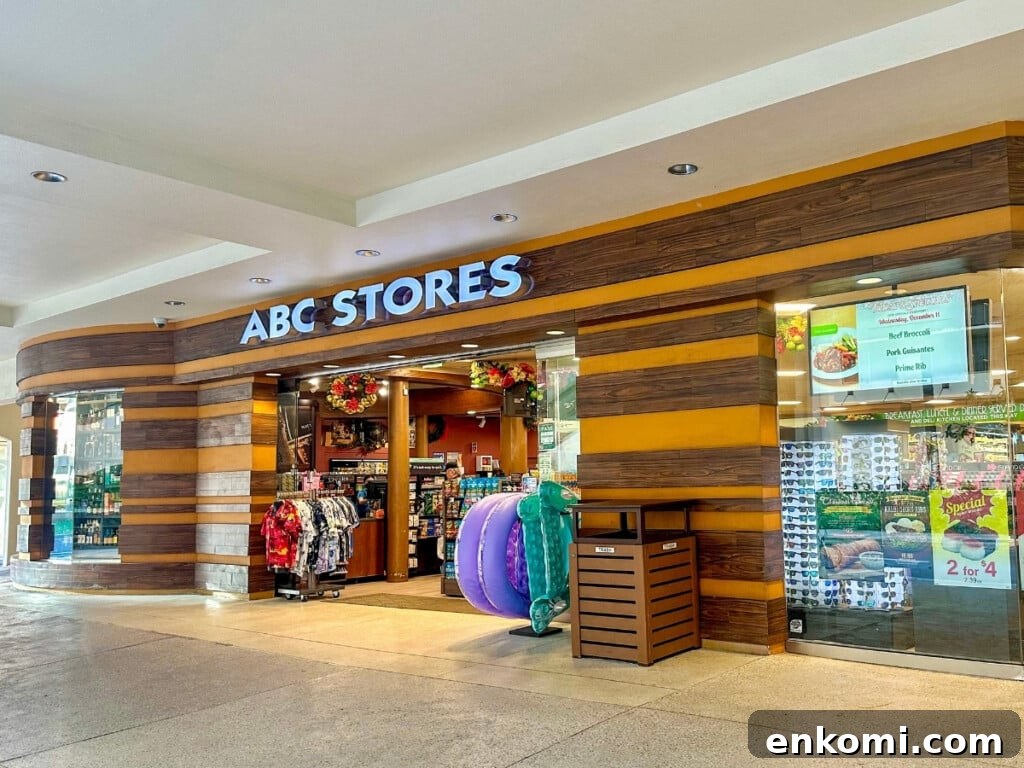 The entrance of ABC Store #38 in Waikīkī featuring a display of Hawaiian shirts and inflatable beach floaties as well as a display of sunglasses in the window.