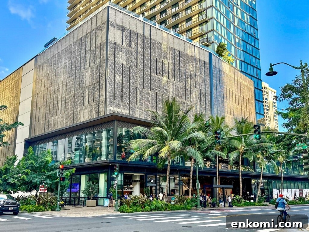 Street view of the exterior building of Waikiki Market on Kūhiō Avenue with palm trees in the foreground.