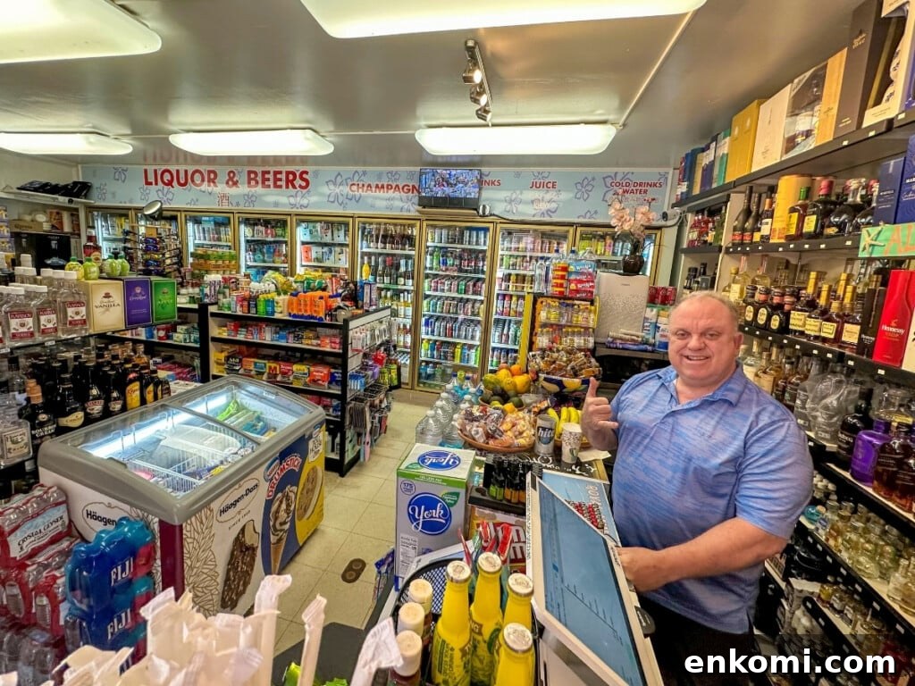 Royal Mini Mart with a display of beverages and every day staples. The cashier behind the counter is smiling and doing a shaka sign.