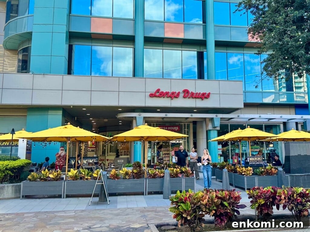 Exterior of Long’s Drugs in Waikīkī featuring yellow umbrellas & outdoor seating at the front.