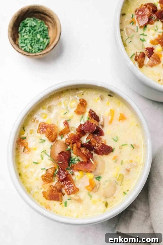 A bowl of corn chowder with bacon sprinkled on top.