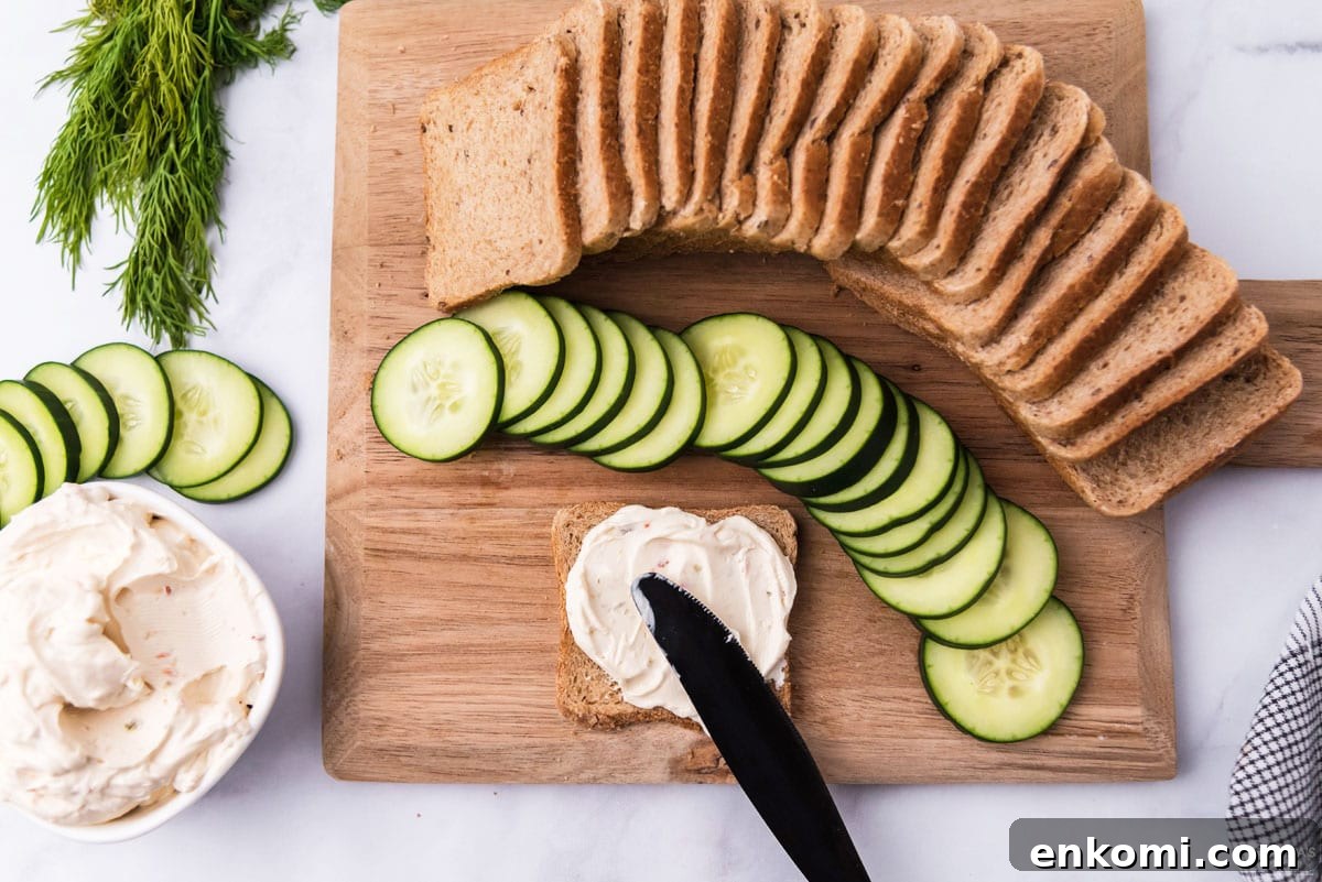 Mini Cucumber Tea Sandwiches for Parties and Picnics 5 spreading cream cheese on bread