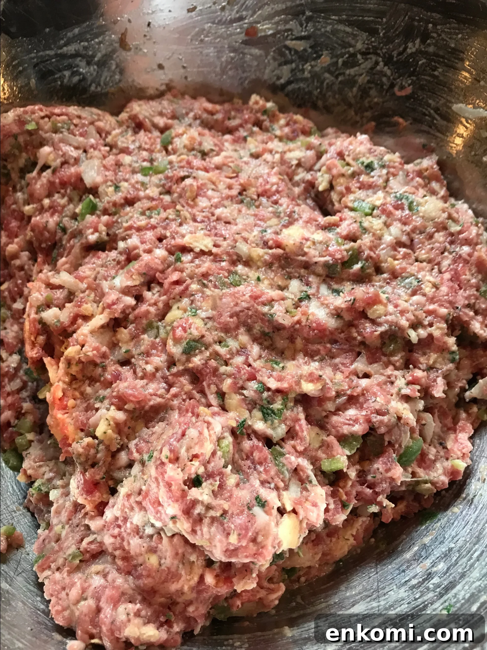 The ground pork mixture in a metal bowl
