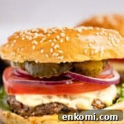 A juicy venison burger piled with onion, cheese, and pickles