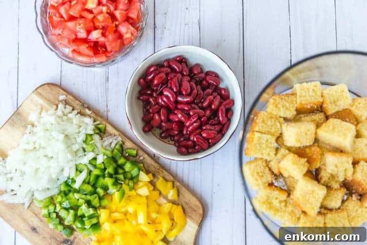 Classic Southern Cornbread Salad Recipe 4 small bowls of tomatoes, kidney beans and cutting board of onions and peppers.