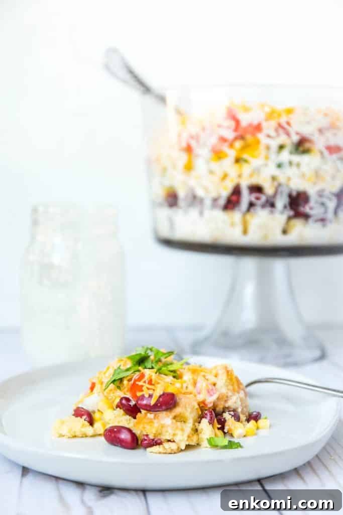 Classic Southern Cornbread Salad Recipe 7 A photo of a plate of cornbread salad with the trifle bowl in the background