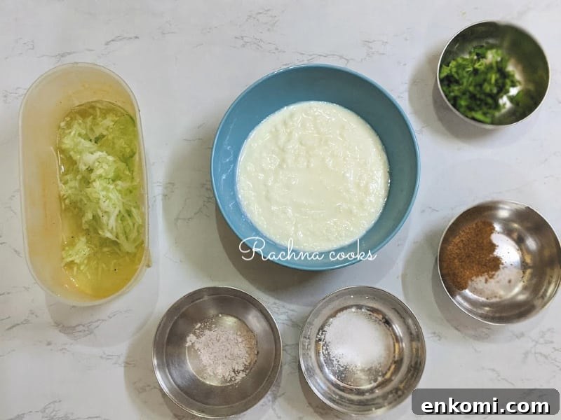 Cucumber Raita: Authentic Indian Cucumber Salad Recipe 3 Bowl of Greek yogurt, grated cucumber, Himalayan pink salt, salt, cumin powder and chopped cilantro.