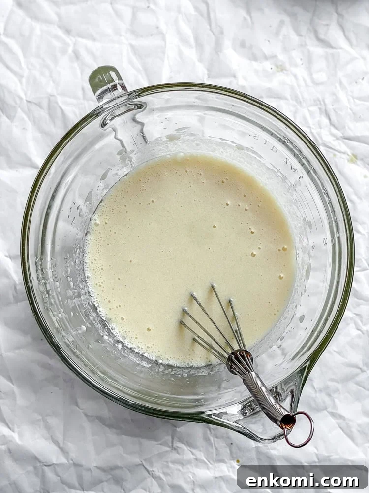 Process shot showing whisking ingredients in a glass container.