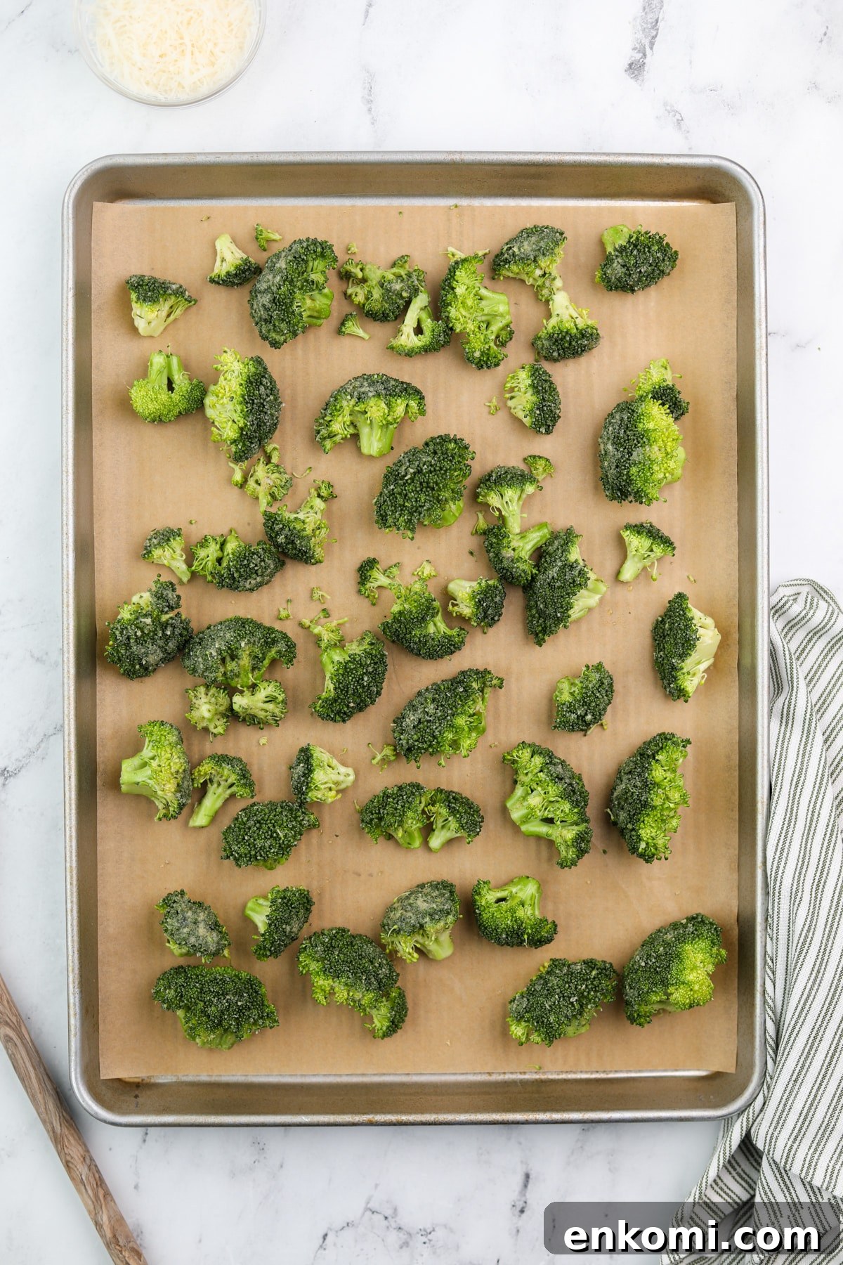 Broccoli florets spread onto a lined baking dish.