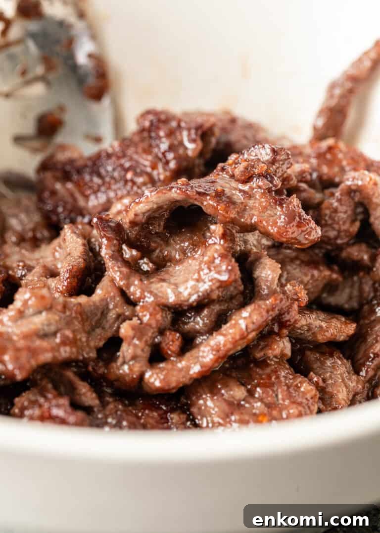 closeup: stir fried strips of beef in white bowl