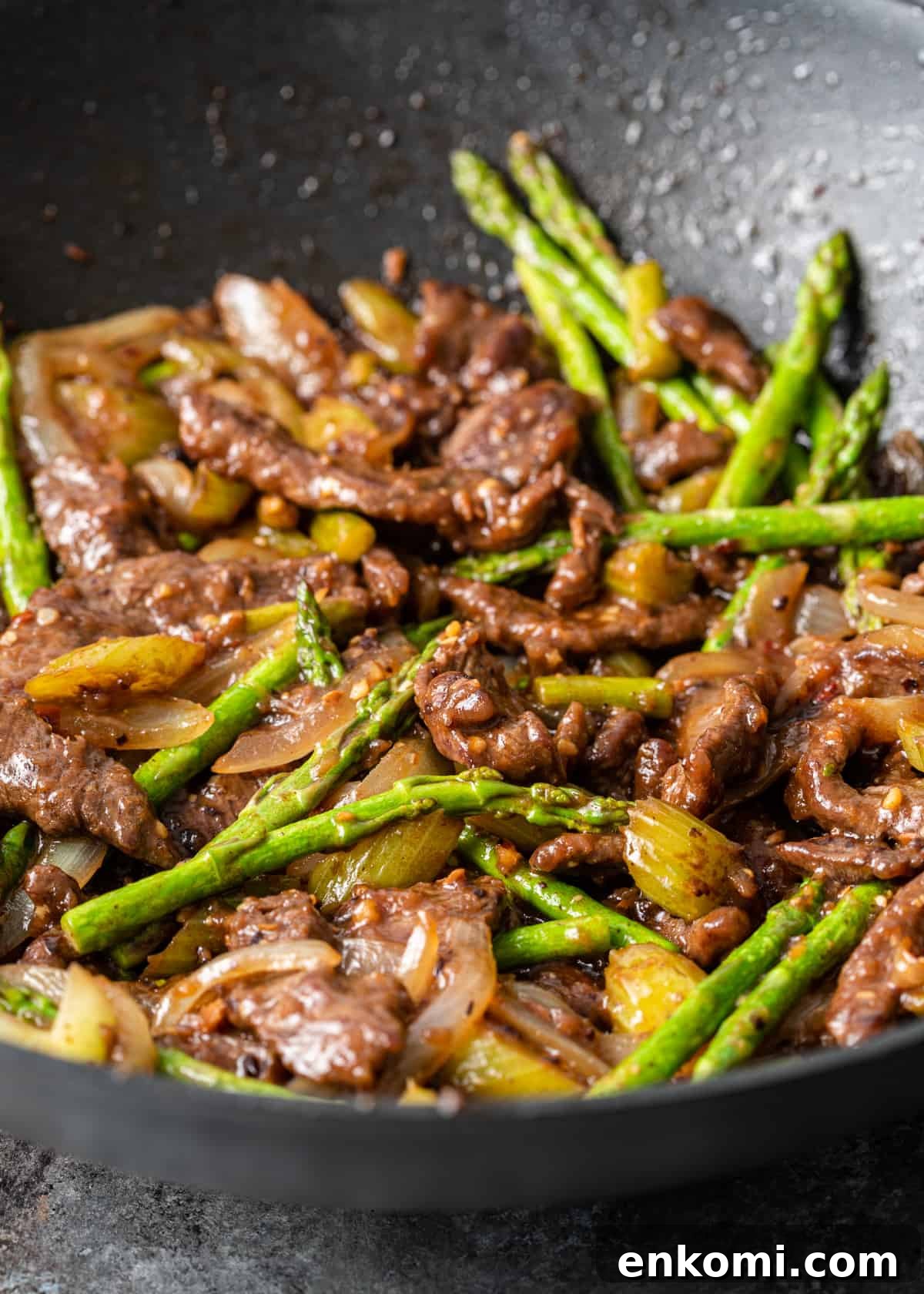 stir frying asparagus tips, onions, celery and strips of sirloin in wok