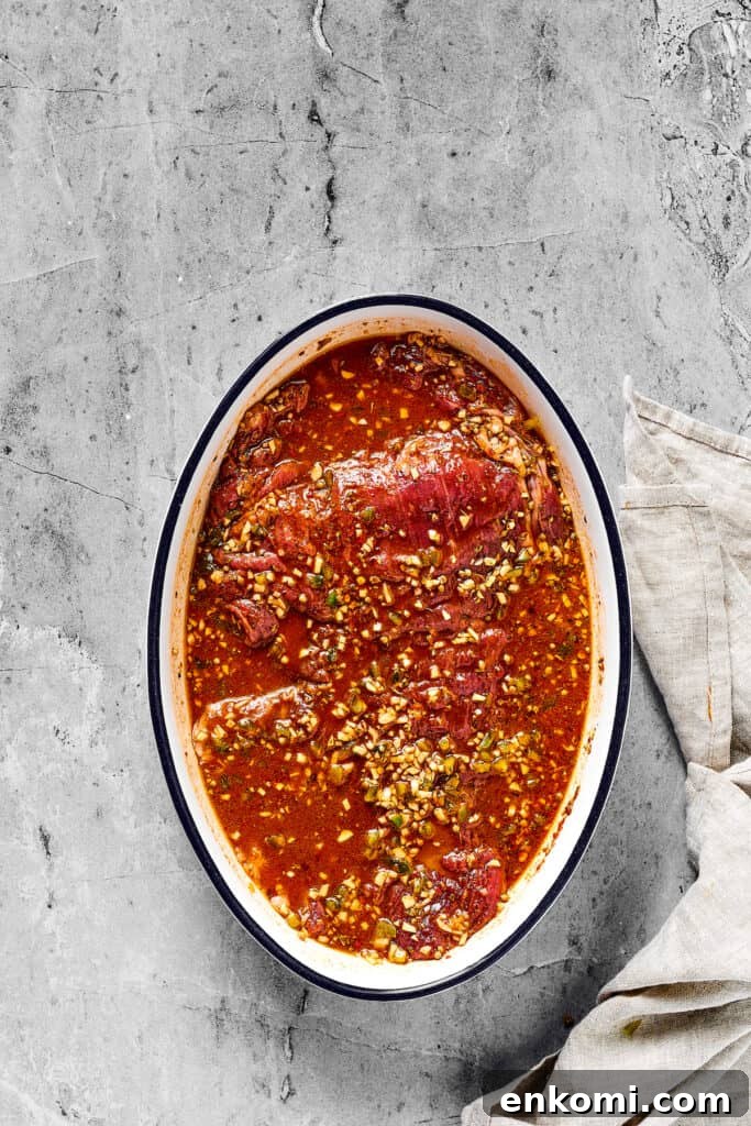 Flank steak fully covered by a marinade with garlic and jalpano.