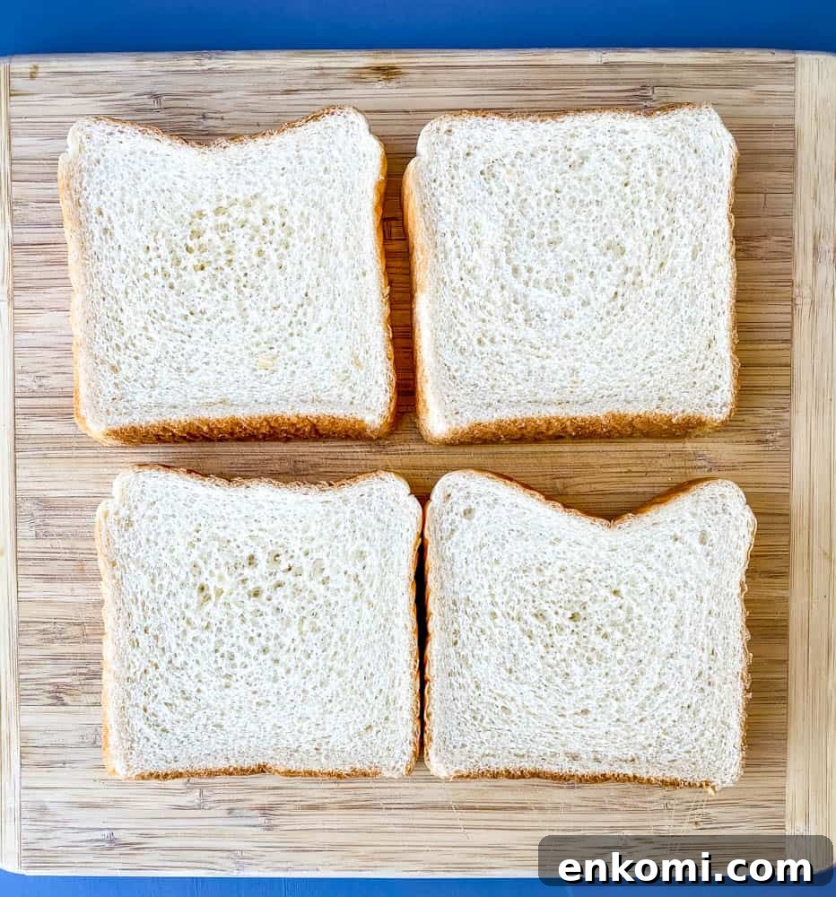 Crispy Air Fryer French Toast Sticks Recipe 4 4 slices of Texas toast bread on a wooden cutting board