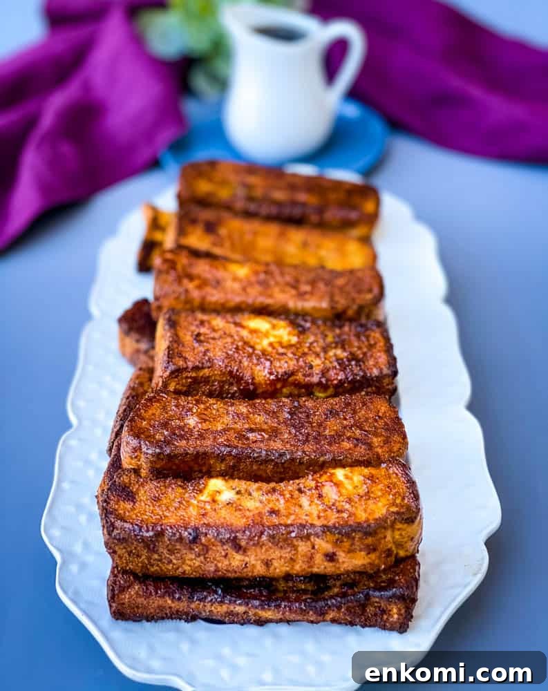 Crispy Air Fryer French Toast Sticks Recipe 9 air fryer French toast sticks on a white plate