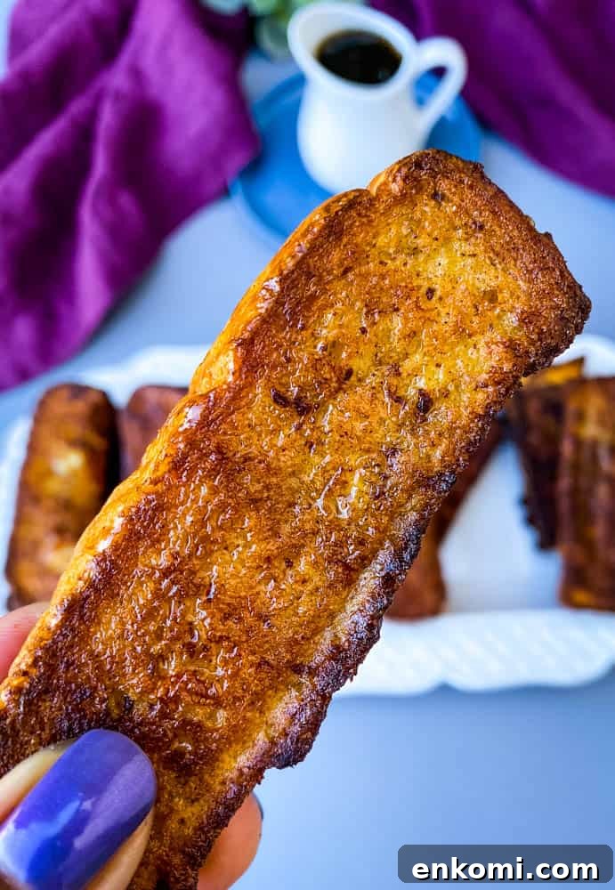 Crispy Air Fryer French Toast Sticks Recipe 10 person holding air fryer French toast stick