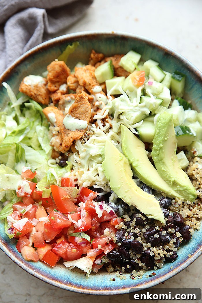 Chicken Quinoa Burrito Bowl with pico de Gallo, black beans, chopped lettuce, cucumber and sliced avocado.