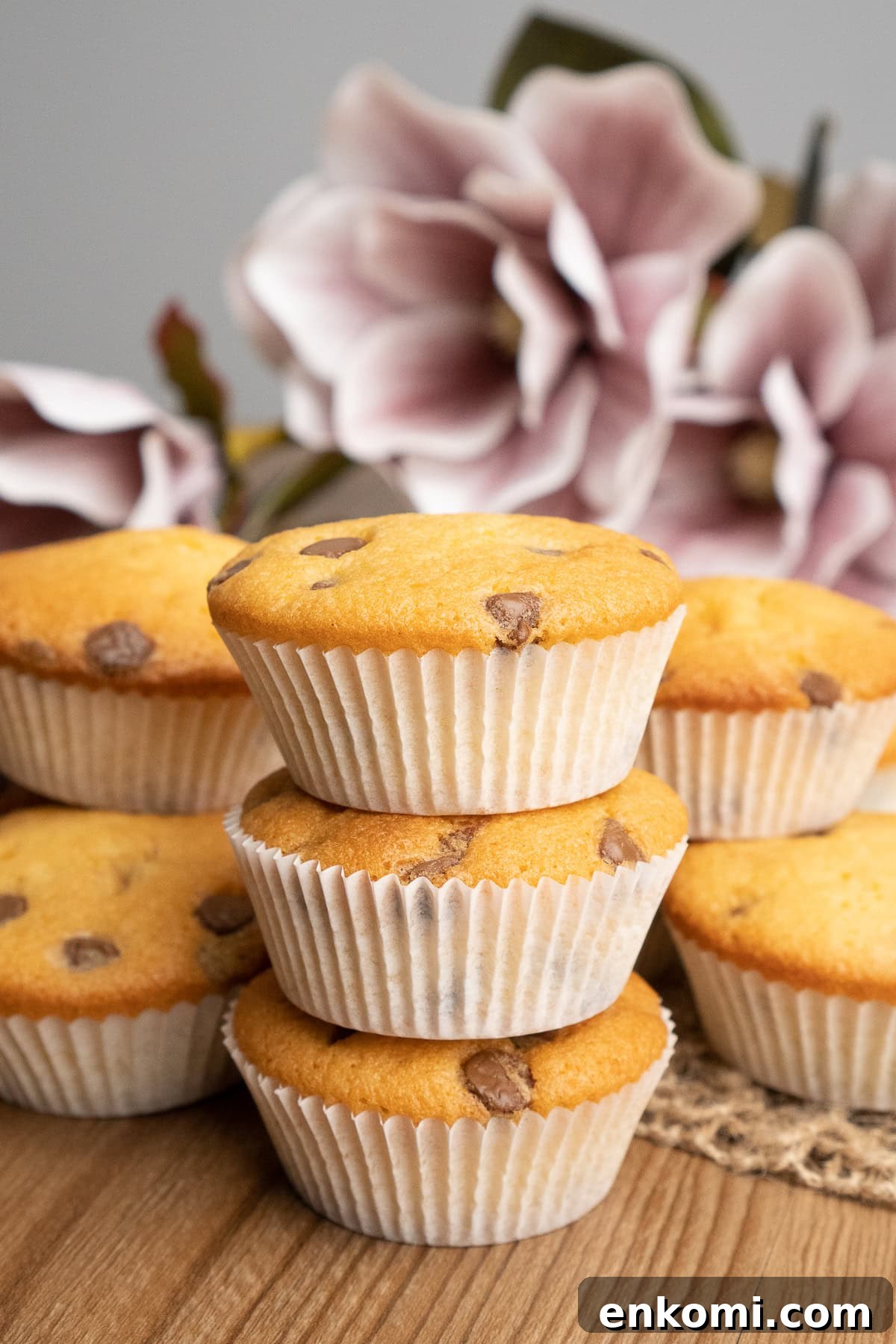 Small chocolate chip cupcakes stacked on top of each other. with white paper cases. 