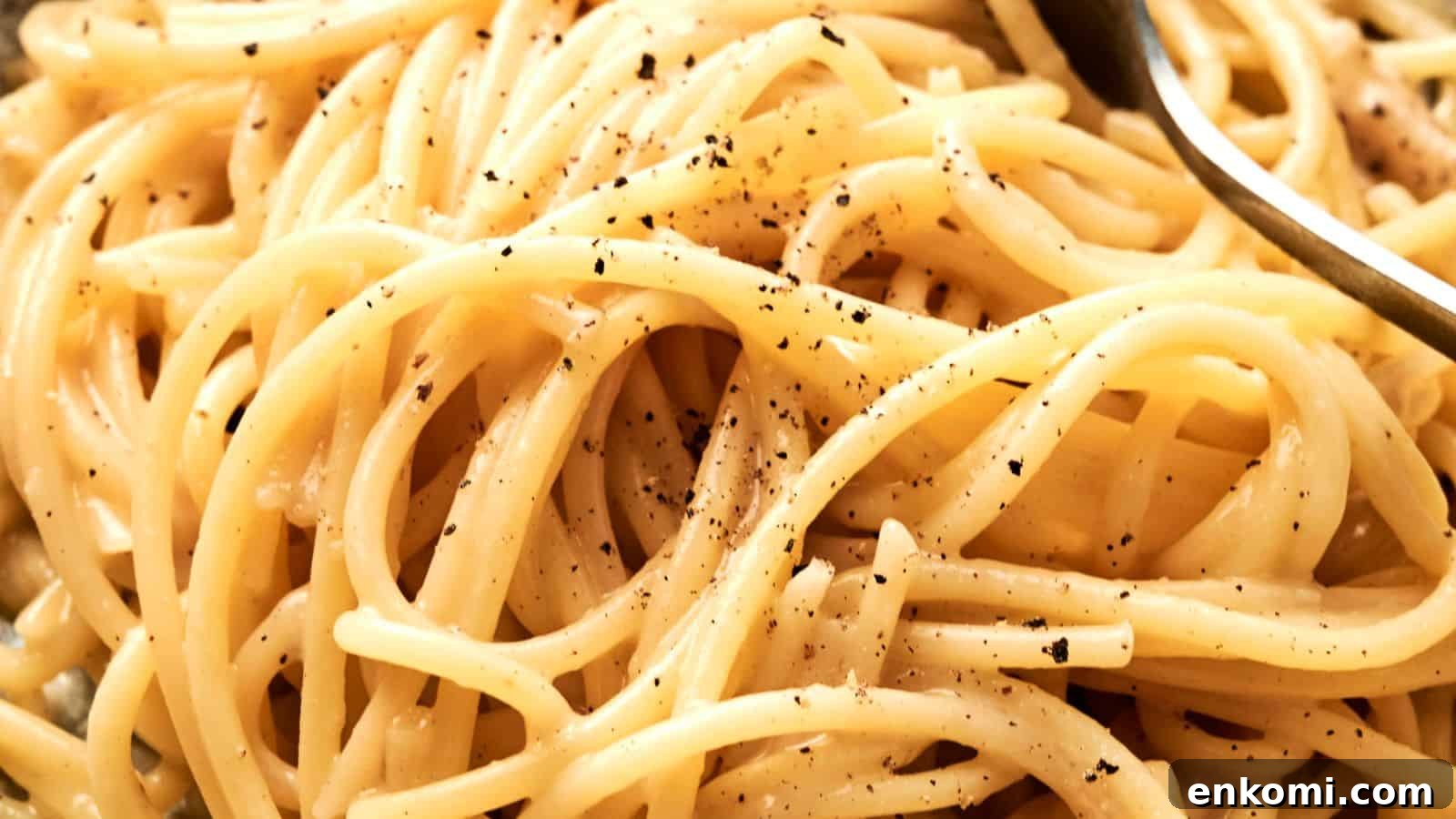 31 Spring Dinners That Feel Fresh, Not Fussy 15 Close-up of cooked spaghetti with cracked black pepper and a fork partially visible.