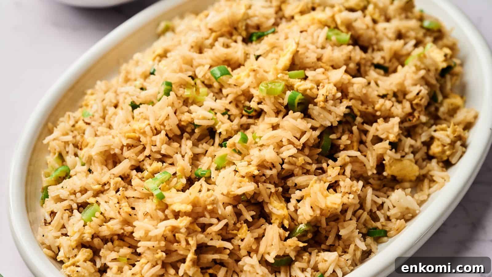 31 Spring Dinners That Feel Fresh, Not Fussy 16 Oval dish filled with fried rice garnished with chopped green onions.
