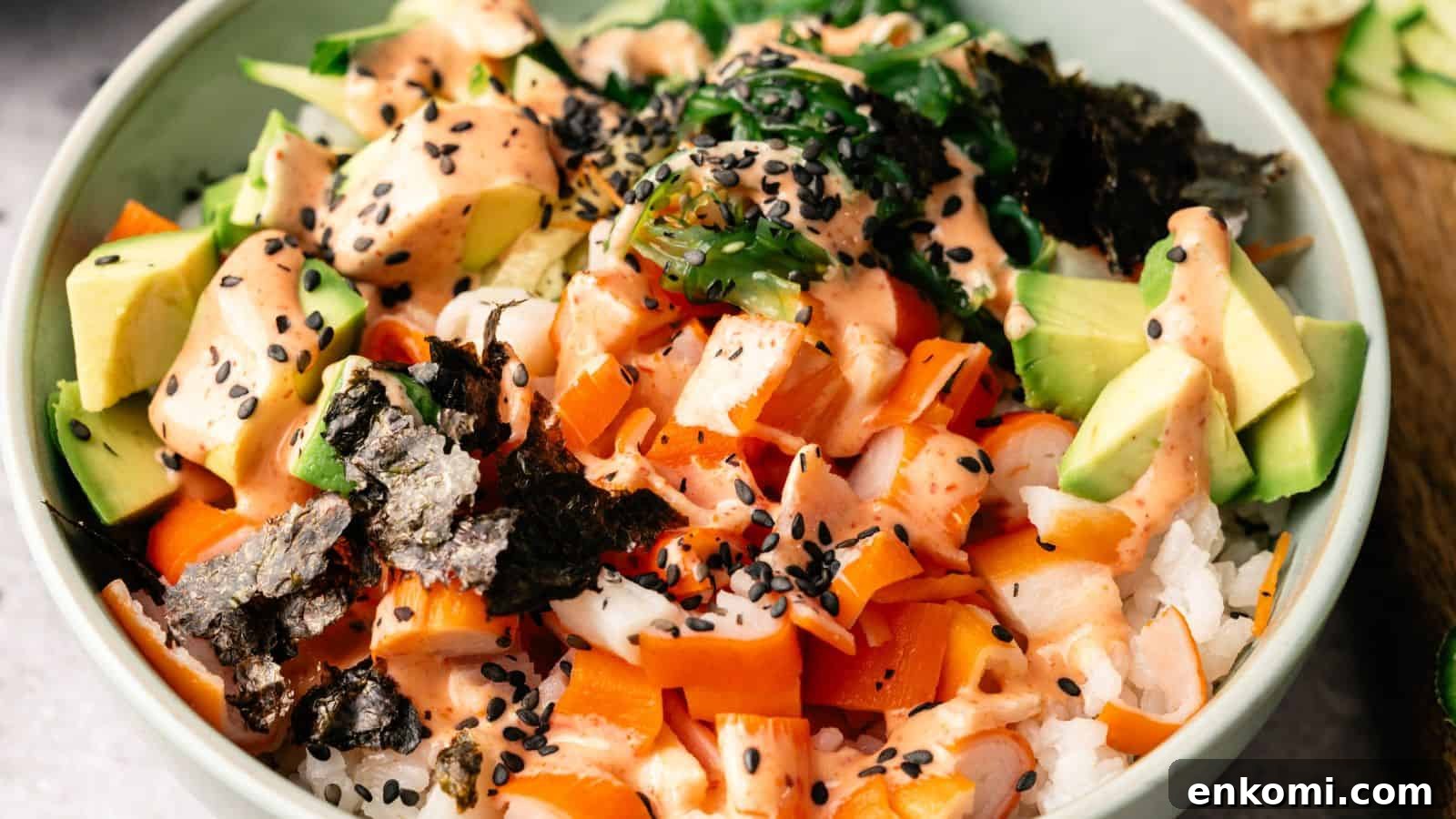 31 Spring Dinners That Feel Fresh, Not Fussy 6 A bowl of sushi rice topped with diced avocado, raw fish, seaweed, carrots, black sesame seeds, and a creamy orange sauce.