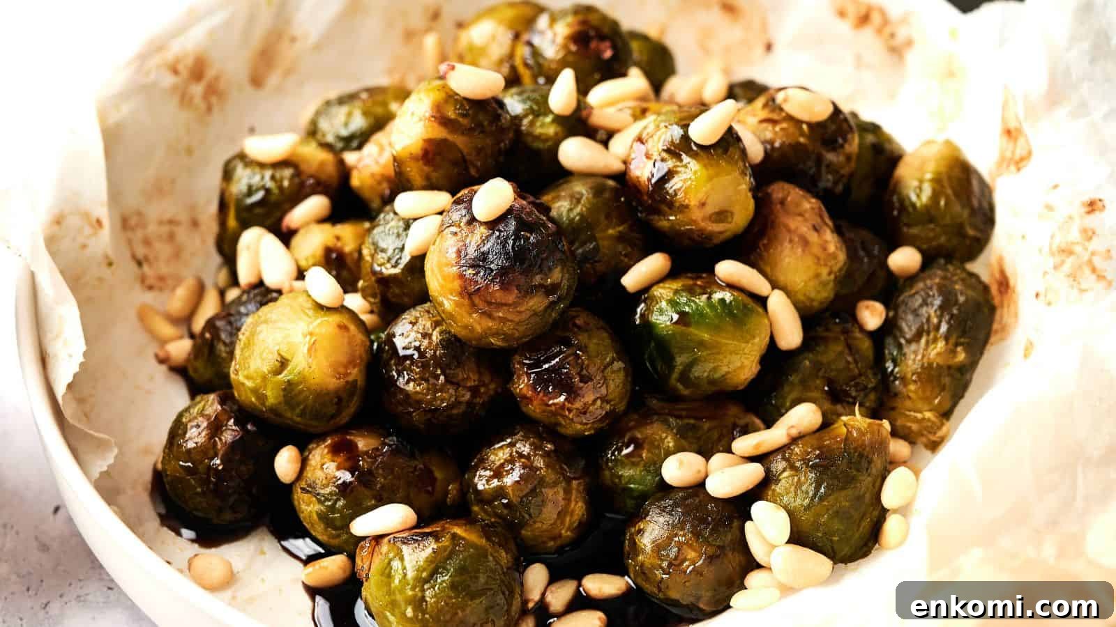 31 Spring Dinners That Feel Fresh, Not Fussy 8 A plate of roasted Brussels sprouts topped with pine nuts on parchment paper.