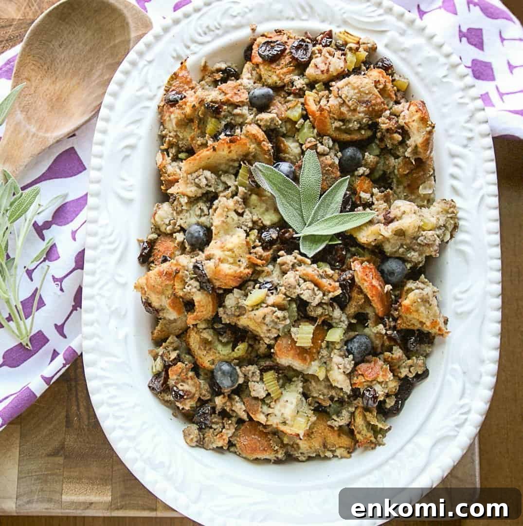 Blueberry Sourdough Sausage Stuffing for Thanksgiving 5 Blueberry sourdough sausage stuffing in a white embossed serving dish with a wooden spoon
